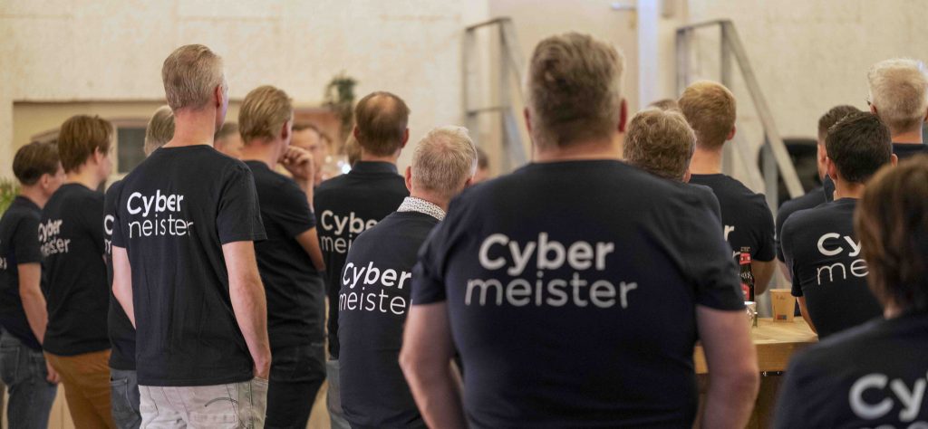 Cybersecurity-specialisten van Cybermeister in teamshirts tijdens zakelijke bijeenkomst